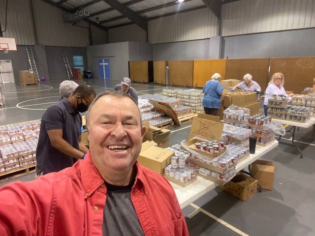 Wayne and his co-workers happily repacking donation while taking picture